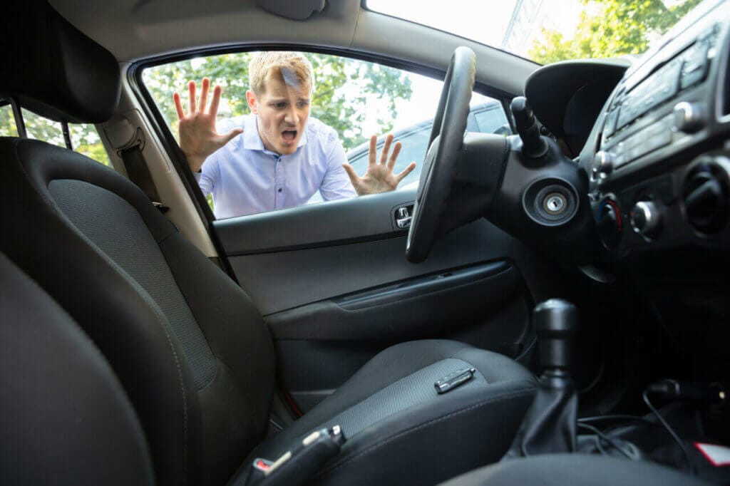 A distressed person looking through window at the keys locked in car