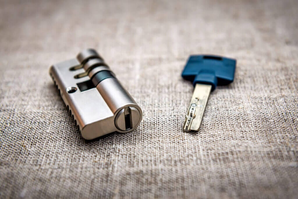 A Lock Cylinder And Key Laid On A Surface