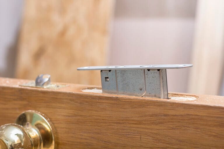A mortise lock being slid into the mortise pocket