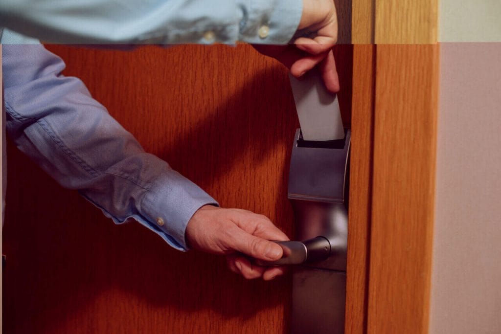 A Person Attempting To Open An Electronic Door Lock With A Card