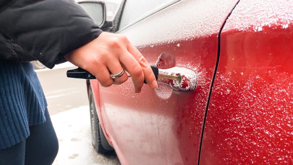 A Person Trying To Open A Frozen Lock