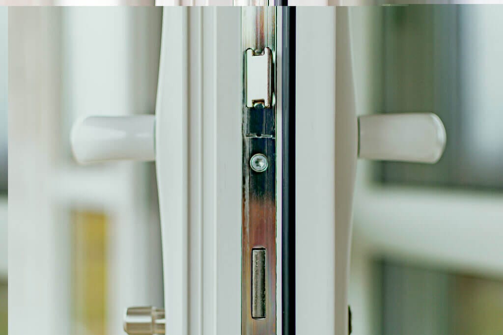 A white door with a mortise lock halfway open