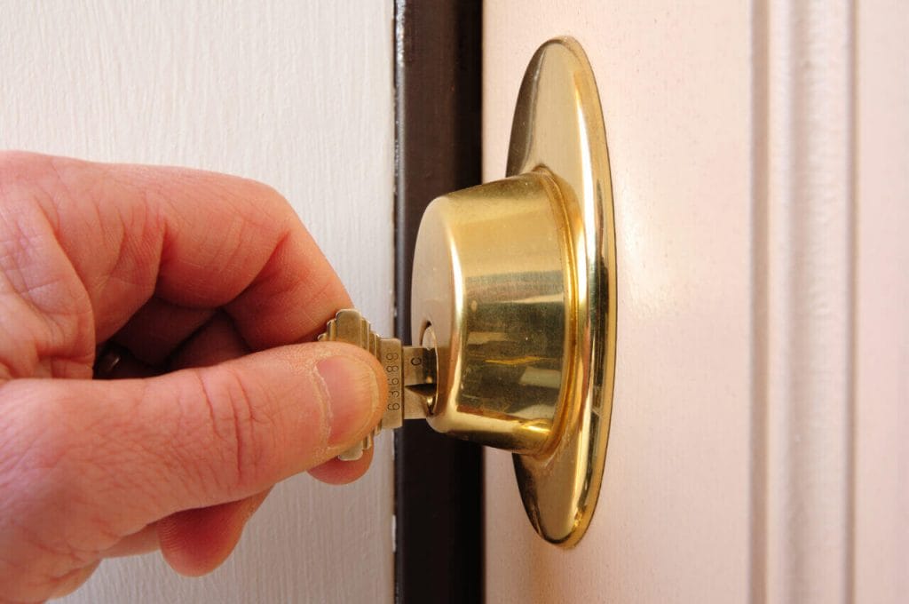 Close Up Of A Hand Locking A Deadbolt Door Lock