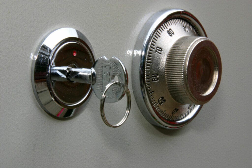 Close up of a mechanical safe dial and a backup physical key